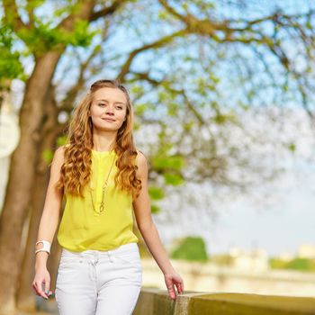 Beautiful young girl walking in Paris on a sunny summer or spring day