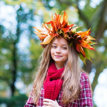 Happy young girl in park on a fall day