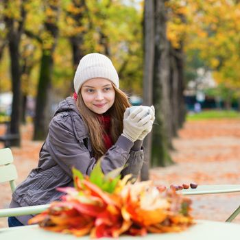 Girl drinking coffee or tea outdoors on a fall day