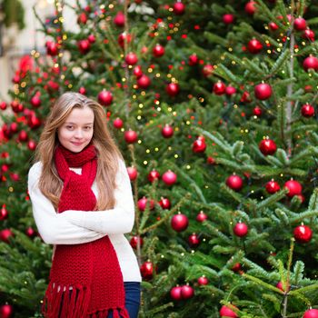 Girl with a brightly decorated Christmas tree