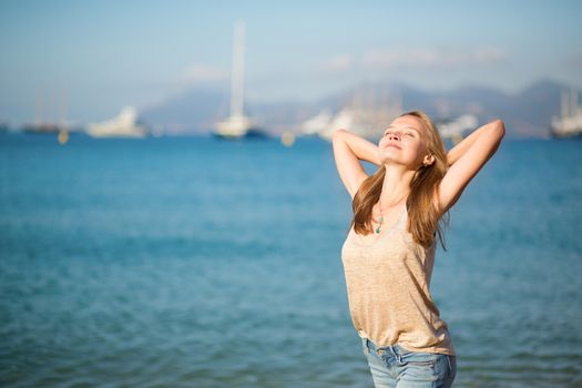 Beautiful young girl enjoying her vacation by the sea