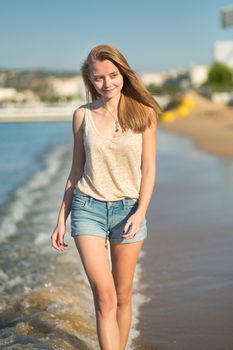 Beautiful young girl walking on the beach