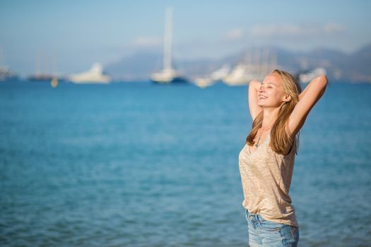 Young girl relaxing near the sea and enjoying her vacation