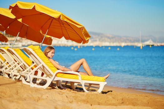 Beautiful girl relaxing on a beach chair near the sea