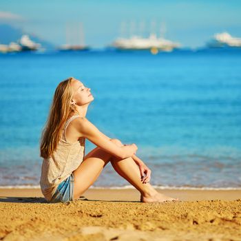 Beautiful young girl enjoying her vacation by the sea