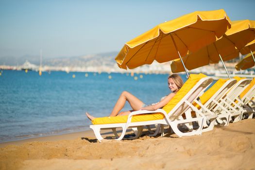 Beautiful girl relaxing on a beach chair near the sea
