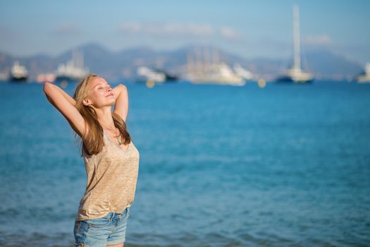 Young girl relaxing near the sea and enjoying her vacation