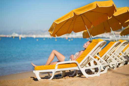 Beautiful girl relaxing on a beach chair near the sea