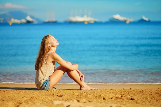 Beautiful young girl enjoying her vacation by the sea