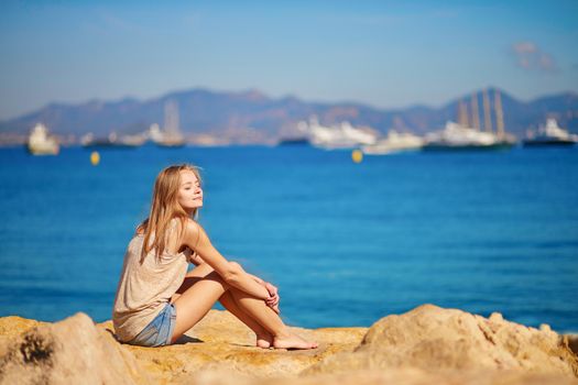 Beautiful young girl enjoying her vacation by the sea
