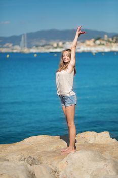 Beautiful young girl enjoying her vacation by the sea