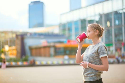 Girl drinking coffee at La Defense, business district of Paris