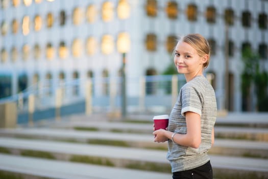 Young beautiful business woman drinking coffee outdoors