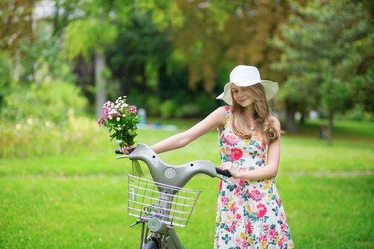 Beautiful young girl with bicycle in the countryside