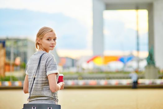 Girl with take-away coffee at La Defense, business district of Paris 
