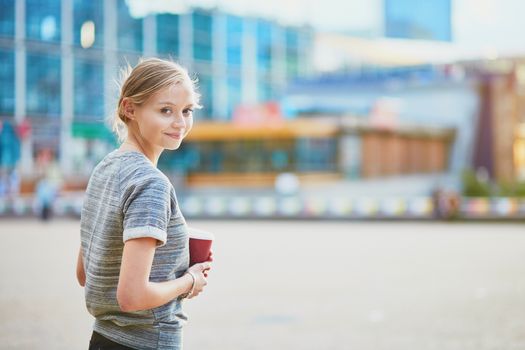 Young beautiful woman having her coffee break outside of the office or university