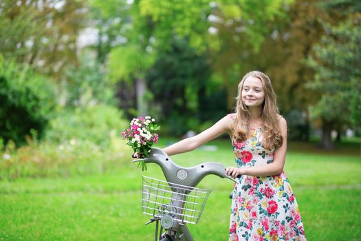 Beautiful young girl with bicycle in the countryside
