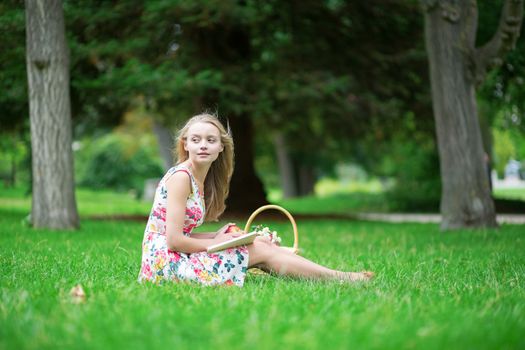 Beautiful young girl in the countryside, reading a book 