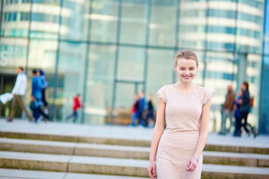 Beautiful young business woman in modern glass office interior