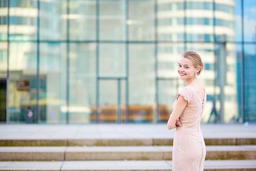 Beautiful young business woman in modern glass office interior