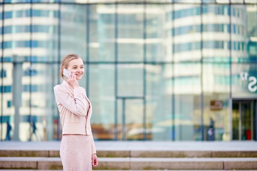 Beautiful young business woman in modern glass office interior