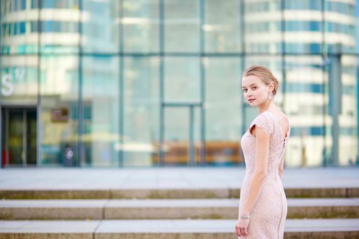 Beautiful young business woman in modern glass office interior