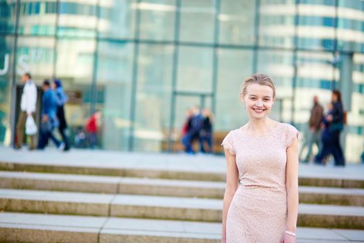 Beautiful young business woman in modern glass office interior