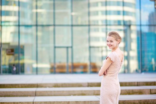 Beautiful young business woman in modern glass office interior
