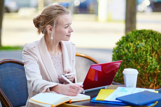 Young businesswoman on a coffee break, working on her laptop. Quarantine and closed offices during coronavirus outbreak