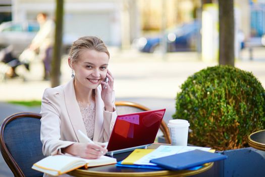 Young businesswoman on a coffee break, working on her laptop