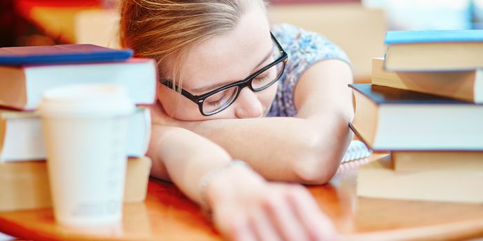 Exhausted student with books and papers, studying at home. Quarantine and closed schools and offices during coronavirus outbreak. Homeschooling, distance learning and freelance job