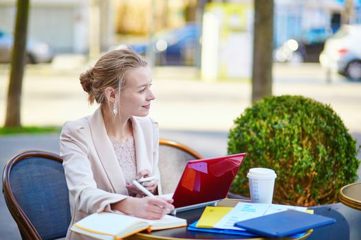 Young businesswoman on a coffee break, working on her laptop