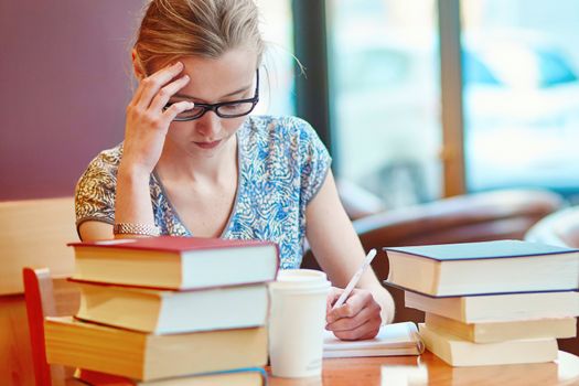 Student with books and papers, studying at home. Quarantine and closed schools and offices during coronavirus outbreak. Homeschooling, distance learning and freelance job