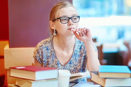 Student with books and papers, studying at home. Quarantine and closed schools and offices during coronavirus outbreak. Homeschooling, distance learning and freelance job