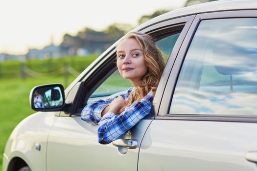 Beautiful young driver looking out of the car window