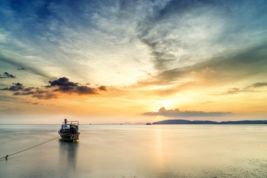Traditional long-tail boat on the beach in Krabi Thailand at sunset