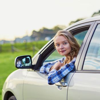 Beautiful young confident woman driving a car