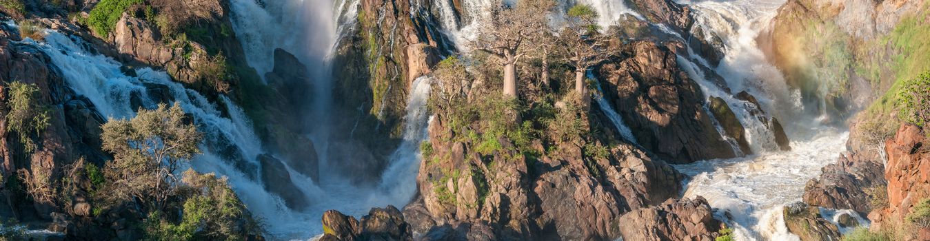 A stitched panorama of part of the Epupa waterfalls in the Kunene River. Baobab trees are visible