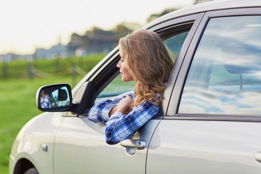 Beautiful young confident woman driving a car