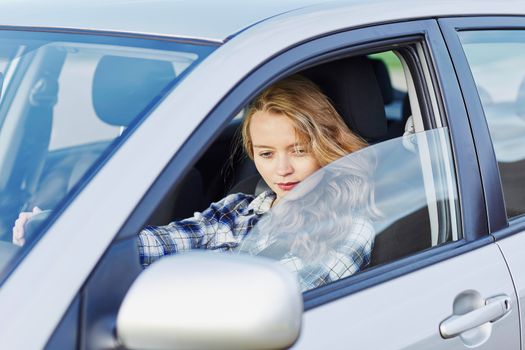 Beautiful young confident woman driving a car
