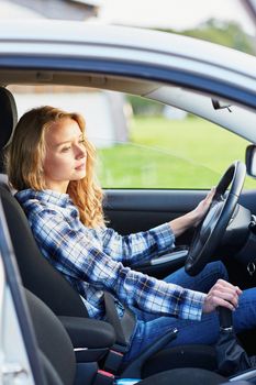 Beautiful young confident woman driving a car
