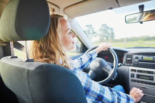 Beautiful young confident woman driving a car