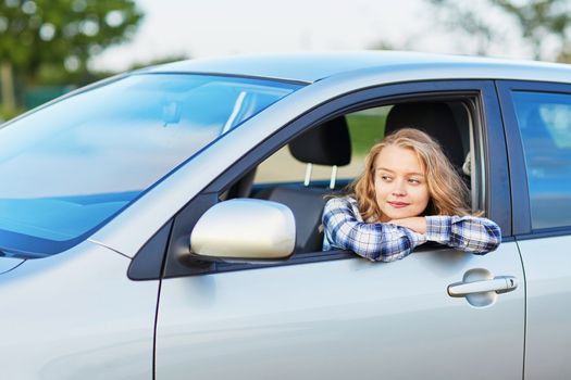 Beautiful young confident woman driving a car