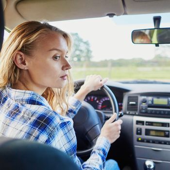 Beautiful and confident young woman driving a car