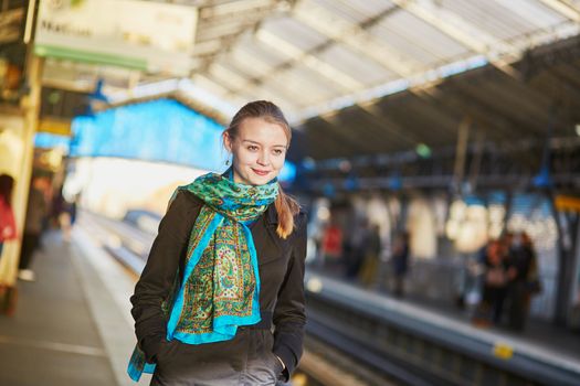 Beautiful young woman waiting for a train on the platform of Parisian underground