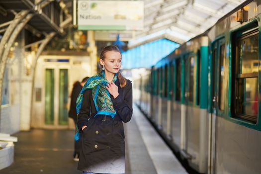Beautiful young woman waiting for a train on the platform of Parisian underground