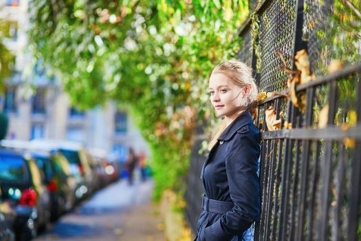 Beautiful young woman on a street of Paris on a sunny fall or spring day