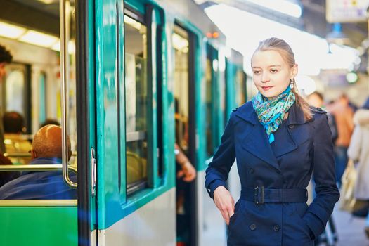 Beautiful young woman waiting for a train on the platform of Parisian underground