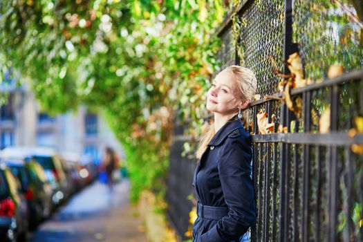 Beautiful young woman on a street of Paris on a sunny fall or spring day