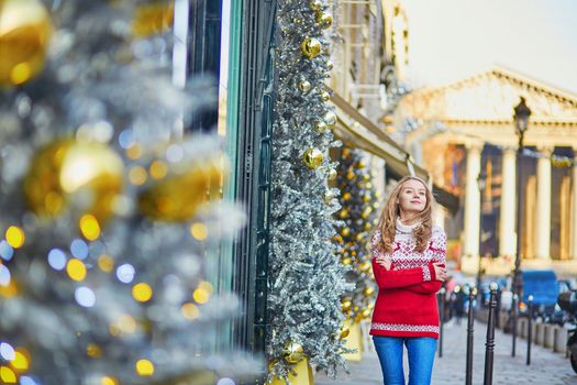 Happy young tourist in Paris on a winter day, Madeleine Church in the background